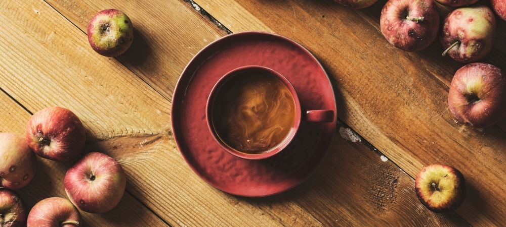 Ist Kaffee gesund? Kaffee zusammen mit Äpfeln auf einem Bild